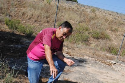 El guia local, amb una cadena d’or sobre la roca gravada, que gira en el sentit de l’espiral.
