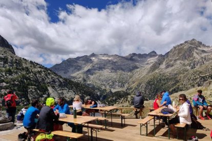 A l’esquerra, estany de Sant Maurici i els Encantats des del mirador de l’estany. A dalt, l’embassament de Cavallers i al costat, la tanca del pàrquing de Cavallers, complet aquesta setmana.