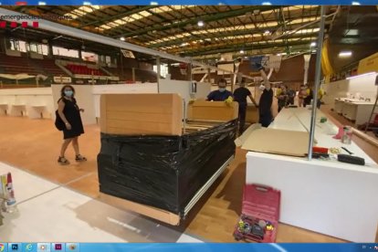 Imágenes de la instalación ayer de camas procedentes de Barcelona en el pabellón Onze de Setembre, que será un hospital.