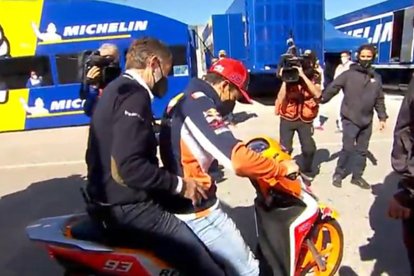 Marc, con el rostro enrojecido, en el box tras la caída. A la derecha, aún en el suelo después de sufrir el aparatoso accidente que dejó prácticamente destrozada la moto.
