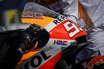 Marc, con el rostro enrojecido, en el box tras la caída. A la derecha, aún en el suelo después de sufrir el aparatoso accidente que dejó prácticamente destrozada la moto.