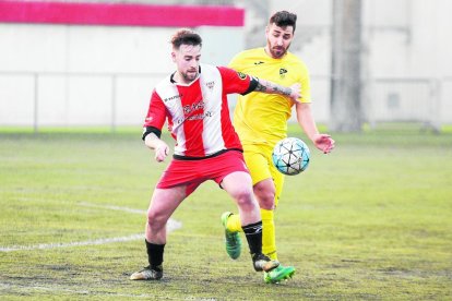 Un jugador del Almacelles pugna con un adversario por el control de un balón dividido.