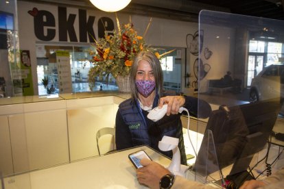Un bar de Lleida, amb cartells que indiquen l’obligació del certificat, comprovant el d’un client.