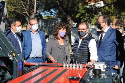 Jordà y Solsona en uno de los tractores expuestos, junto al director, Xavier Roure y el presidente de la Diputación, Joan Talarn, abajo.