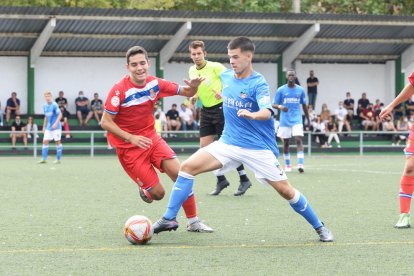 Un jugador del Lleida conduciendo el balón frente a un oponente.