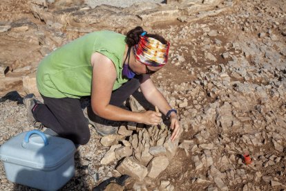 Ôscar Escala, de Iltirta Arqueologia, muestra el nuevo túmulo funerario (izquierda), y la restauradora Gemma Piqué limpia parte de un túmulo descubierto en 2015 (derecha).