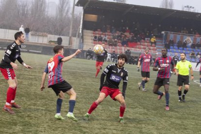 El local Izán pugna con un rival en un balón dividido .