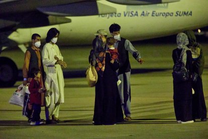 Un militar britànic saluda un menor afganès a punt d’embarcar en un avió que el traurà de Kabul.