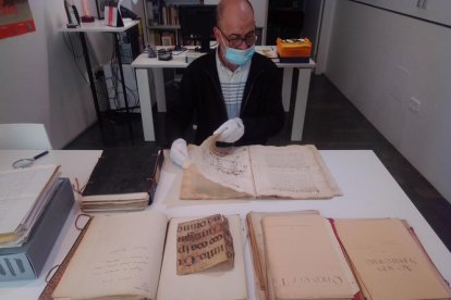 A la derecha, Josep Segura con la documentación de Eduard Mias en el Espai Macià, entre ella un censo del XVII (arriba).