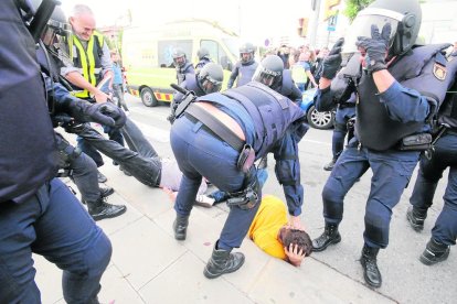 Agentes de la Policía Nacional arrastran a votantes ante la EOI de Lleida en la jornada del 1-O.