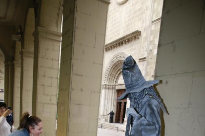 Una niña saludando a un estatua que encarnaba a Merlín.