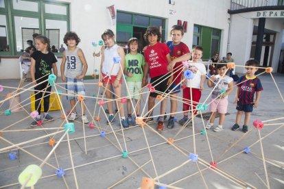 Foto de família dels organitzadors i bona part dels artistes participants en l’Embarrat (esq.) i Laura Llaneli, una de les guanyadores d’aquesta edició, davant de la seua obra.
