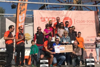 Atletes guanyadors i organitzadors posen mostrant la xifra recollida per a la investigació del trastorn límit de la personalitat.