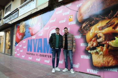 Xavier Llasera i Narcís Dalmau al costat del cartell de reobertura.