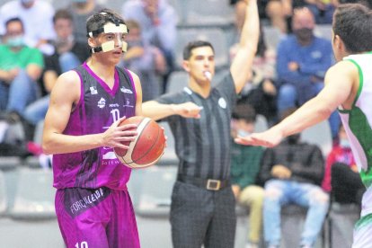 Hughes intenta anotar de forma acrobàtica davant l’oposició de Mbala.