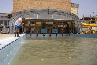 Balaguer. Operarios trabajando ayer para limpiar la piscina, que sufrió daños por las precipitaciones.