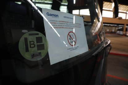 Usuari d’un patinet elèctric llegint un cartell que informa de la nova normativa.