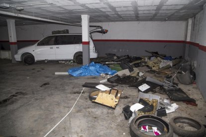 Una entrada al edificio sin puerta, con instalaciones eléctricas rotas y una tapia perforada.