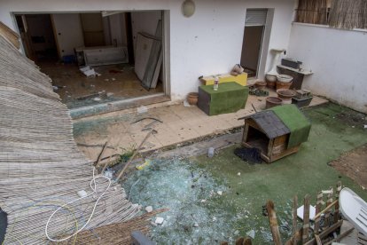 Una entrada al edificio sin puerta, con instalaciones eléctricas rotas y una tapia perforada.