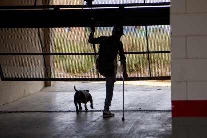 Una entrada al edificio sin puerta, con instalaciones eléctricas rotas y una tapia perforada.