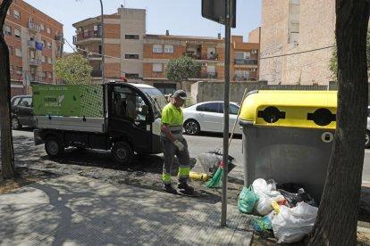 Restes dels contenidors cremats i arbres danyats ahir al carrer Hostal de la Bordeta.