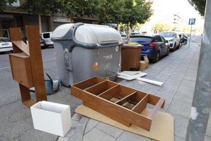 Cajas al lado de un contenedor de papel y cartón en la plaza Santa Maria Magdalena (Clot).