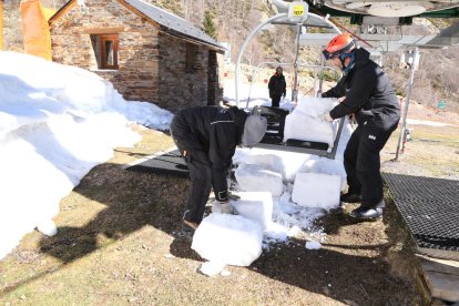 Operarios repartiendo la nieve al inicio de su único telesilla.