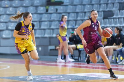 Iris Tribó intenta una entrada a cistella pressionada per una rival.