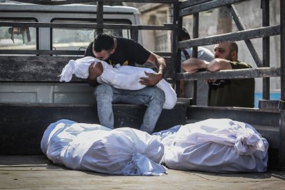 Un palestino besa el cuerpo de un niño muerto durante los ataques israelíes en Gaza.