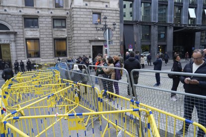Vallas metálicas blindan el recinto del Congreso de los Diputados, con varias personas mirándoselo desde fuera.