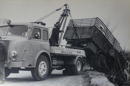Martí Minguella. Dalt del camió grua rescatant un camió. El fill Francesc apareix a l’esquerra.