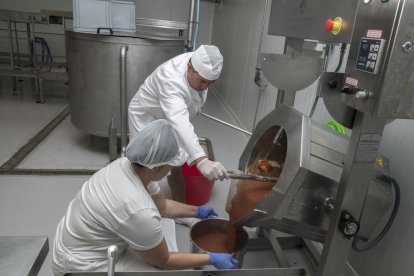 Treballant el codonyat ja triturat que està llest per ser envasat