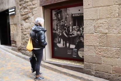 Una persona observa una de las fotografías instaladas en un local vacío de Solsona