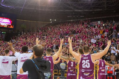 Els jugadors celebren la victòria al costat de la grada bordeus.