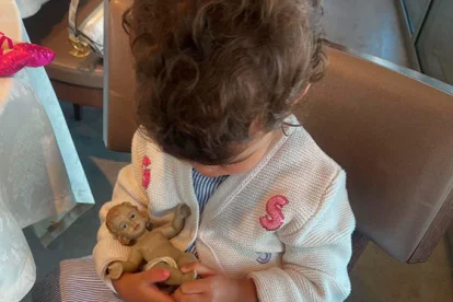La pequeña Bella Esmeralda juega con Niño Jesús recuerdo de Fátima.