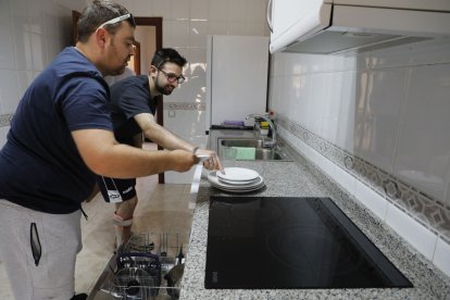 El Xavier i l’Albert, usuaris d’Aspid, posant el rentaplats al seu pisó. - AMADO FORROLLA