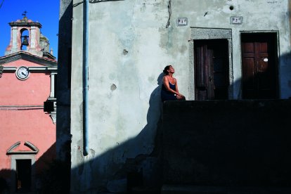 Ombres i colors. Una dona pren el sol en un carreró de la petita població de Marciana, a l’illa d’Elba
