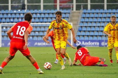 Unai Garcia porta la pilota entre tres rivals de l’Andorra. - JORDI ECHEVARRIA