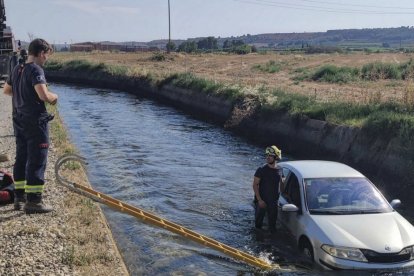 Imatge del vehicle a l’interior del canal i de l’escala que van utilitzar els Bombers per rescatar el conductor, que va resultar il·lès. - BOMBERS ALMENAR