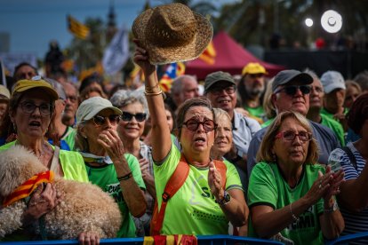 Una asistente al acto político que cierra la manifestación en Barcelona de las entidades independentistas por la Diada, con un sombrero de paja en la mano.