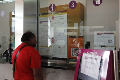 Un usuari del servei, dilluns passat mirant els nous horaris de l’R13 i l’R14. - AMADO FORROLLA