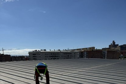 Un dels operaris treballant ahir en la impermeabilització de la coberta del Barris Nord. - AMADO FORROLLA