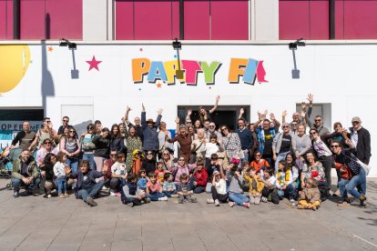 Fotografía de grup de les famílies que van participar ahir en la iniciativa davant del nou local que ocuparà El Genet Blau.