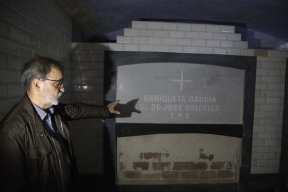 L’alcalde, Dionís Oña, mostra la cripta i el retaule acabat de renovar de la capella del cementiri. - C.MARSIÑACH