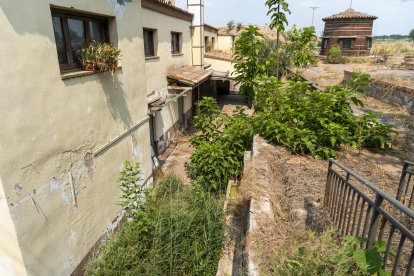 El restaurant a la venda al costat de Masia Salat, al fons, està ple de vegetació i molt degradat.