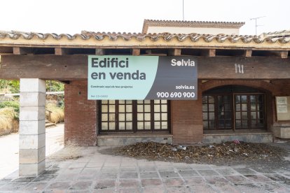El restaurant a la venda al costat de Masia Salat, al fons, està ple de vegetació i molt degradat.