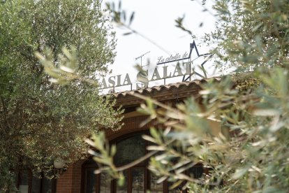 El restaurant a la venda al costat de Masia Salat, al fons, està ple de vegetació i molt degradat.