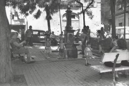 Joc i conciliació. Diversos nens juguen al costat de la font de l’IEI en ple estiu sota la cura dels seus avis, que reposen als bancs. - FONS GÓMEZ VIDAL/ARXIU FOTOGRÀFIC IEI