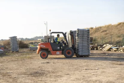 Un operari trasllada flotadors a la zona d’obres. - PAU PASCUAL PRAT