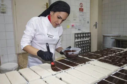 Clients aquesta setmana en una botiga de Torrons Vicens a Agramunt (esquerra) i Zoe Valero de  Torrons Fèlix preparant torrons a les portes del Nadal (dreta). - LAIA PEDRÓS